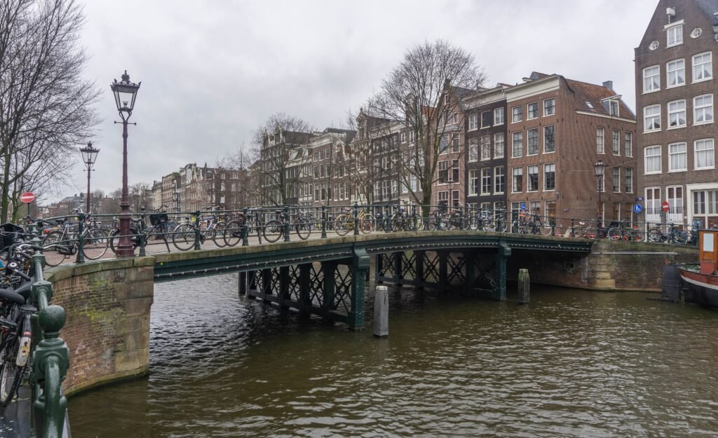 Pedestrians and a bicycle beside a canal bridge in Amsterdam