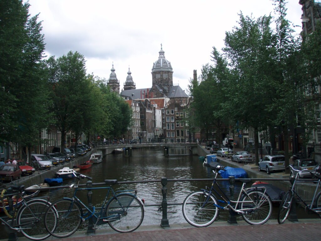 Amsterdam canal with historic buildings, bridges and bicycles along the water