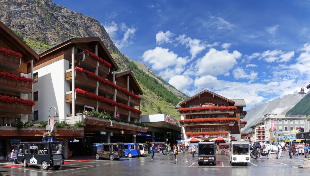Bahnhofplatz in Zermatt with pedestrians and electric vehicles