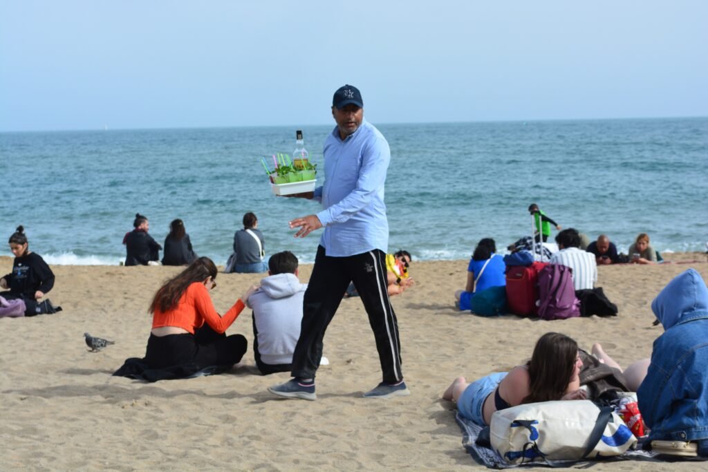 People relaxing on Barceloneta Beach beside the Mediterranean Sea in Barcelona