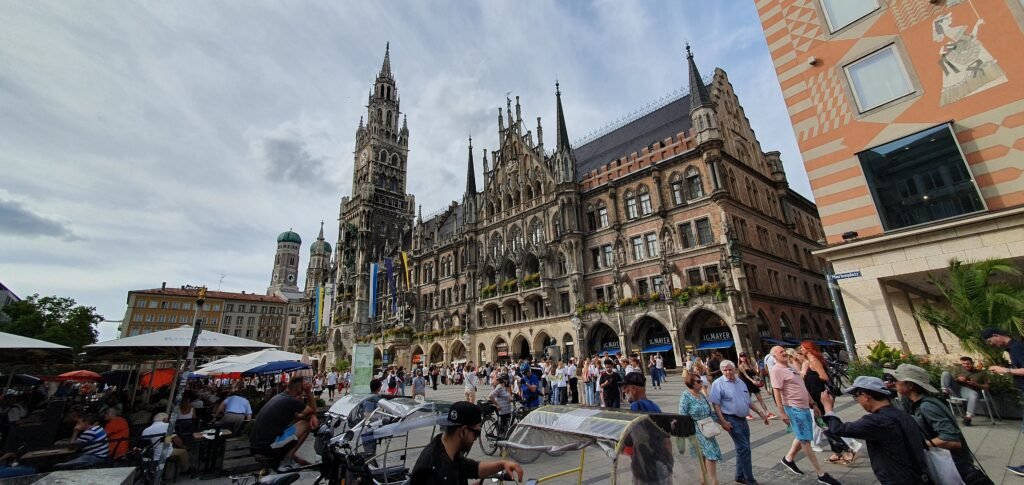 Pedestrians crossing Marienplatz beside Munich’s New Town Hall
