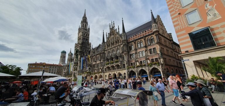 Pedestrians crossing Marienplatz beside Munich’s New Town Hall