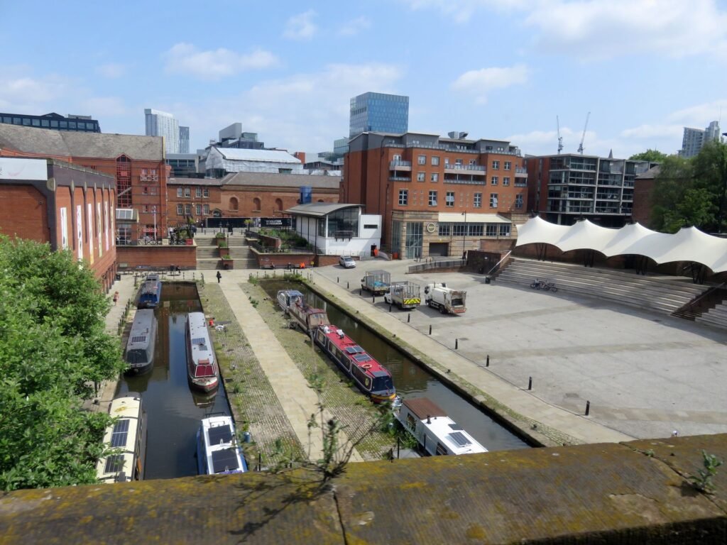 Canal boats and brick buildings around Castlefield Basin in Manchester