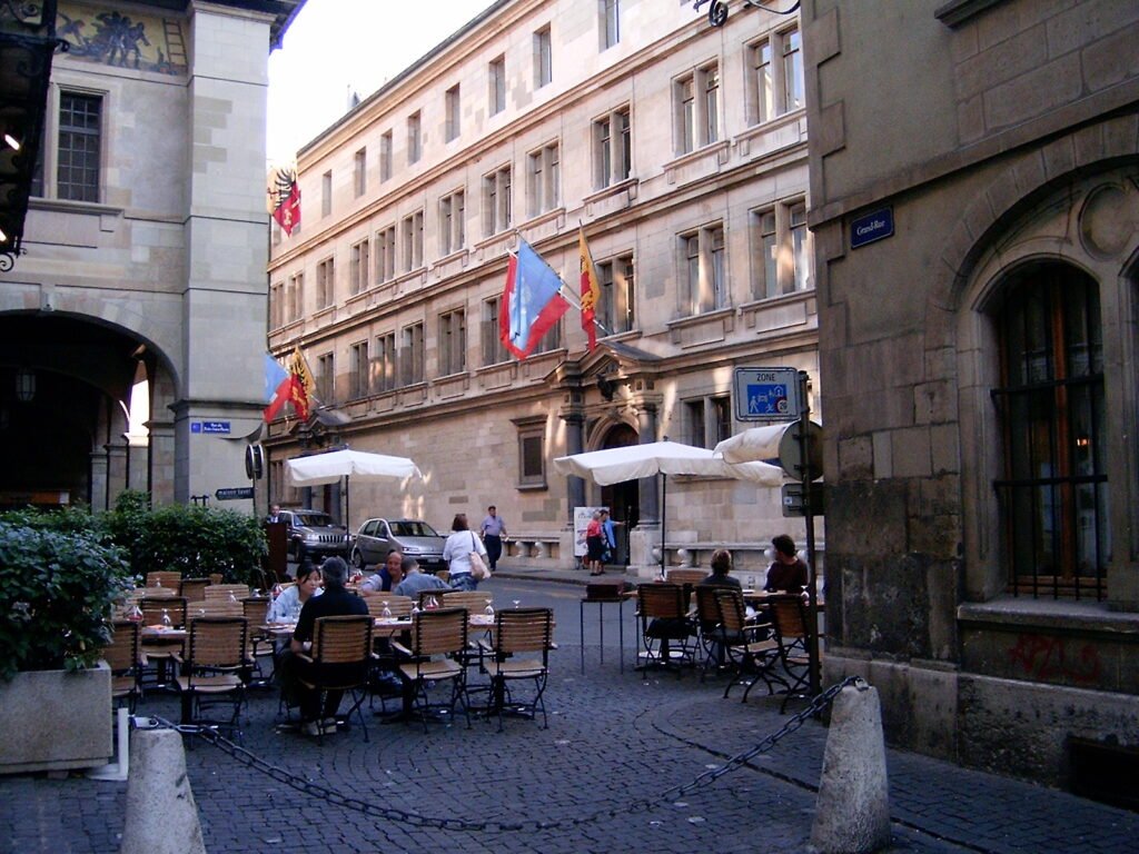 Cobbled street and café terraces in Geneva Old Town near Rue de l’Hôtel-de-Ville
