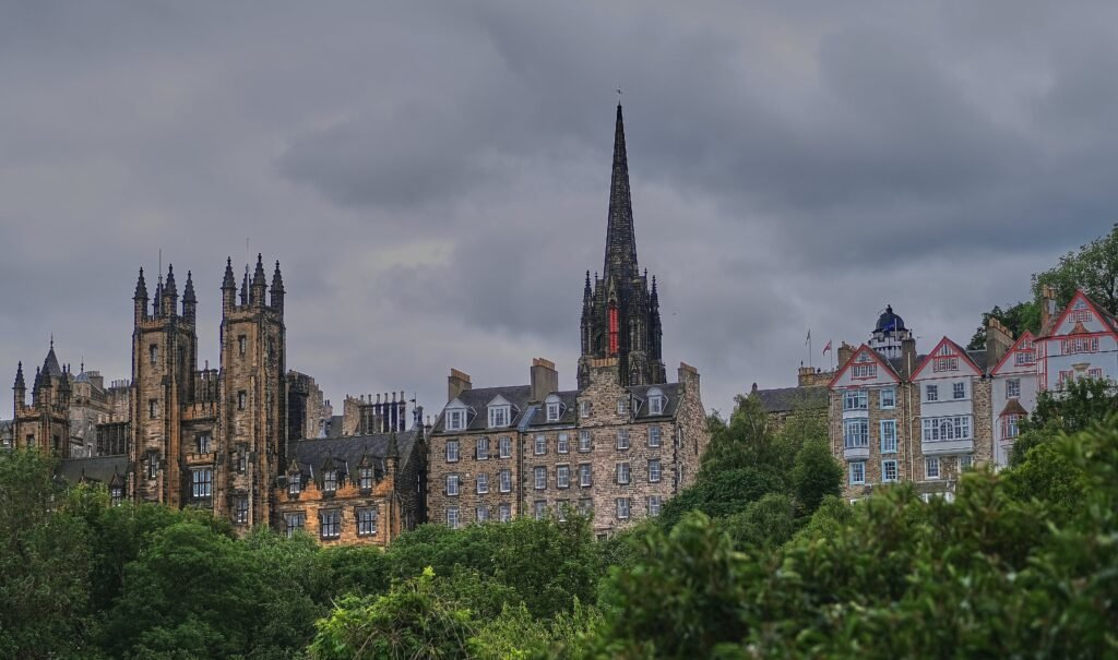 Edinburgh Old Town skyline rising above green slopes and historic stone buildings