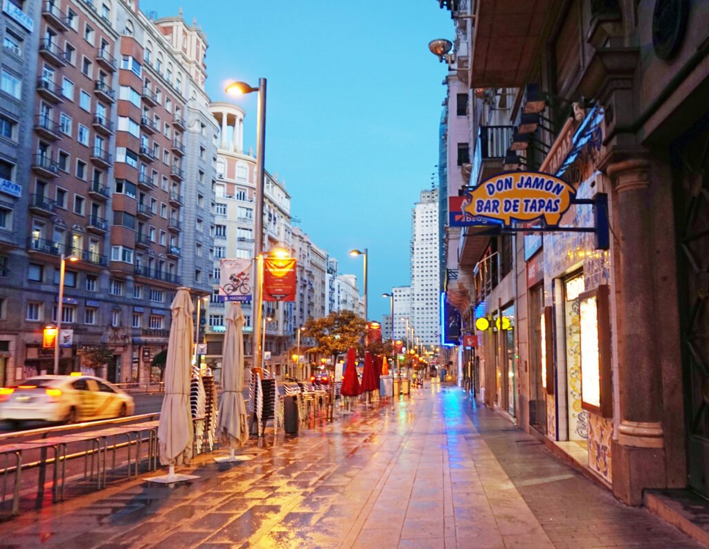 Gran Vía in Madrid with a broad sidewalk, buildings and evening traffic