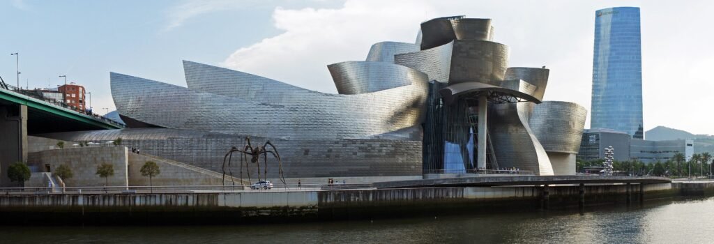 Guggenheim Museum Bilbao beside the Nervión river with the Iberdrola Tower behind