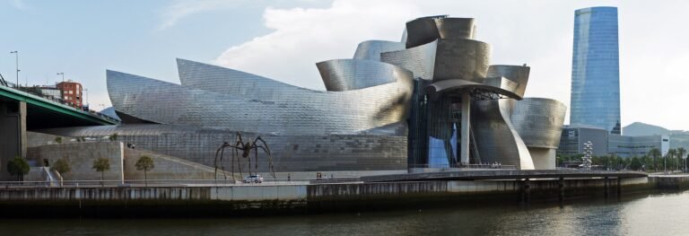 Guggenheim Museum Bilbao beside the Nervión river with the Iberdrola Tower behind