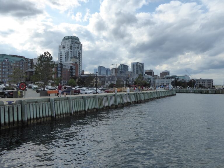 Pedestrians along the Halifax waterfront promenade with downtown buildings beyond
