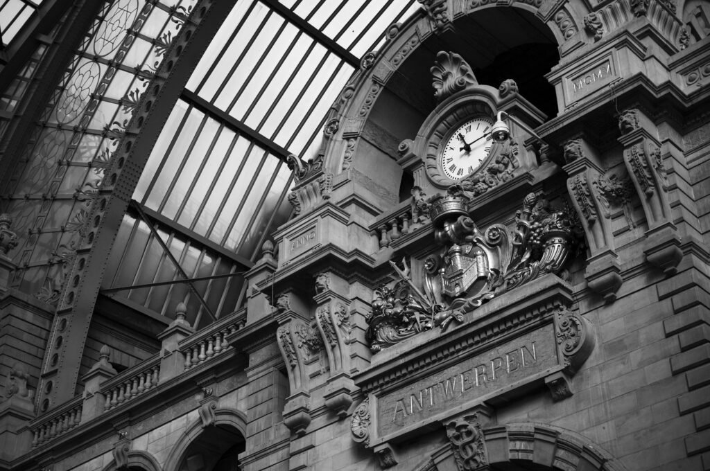 Historic clock and glass roof inside Antwerpen-Centraal railway station