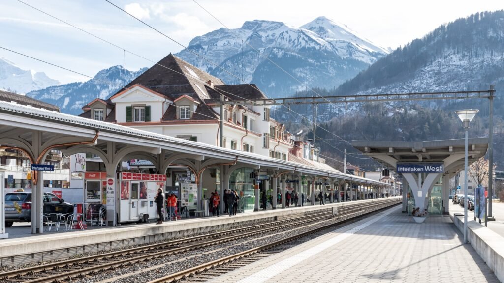 Interlaken West railway station platforms with mountains behind the station