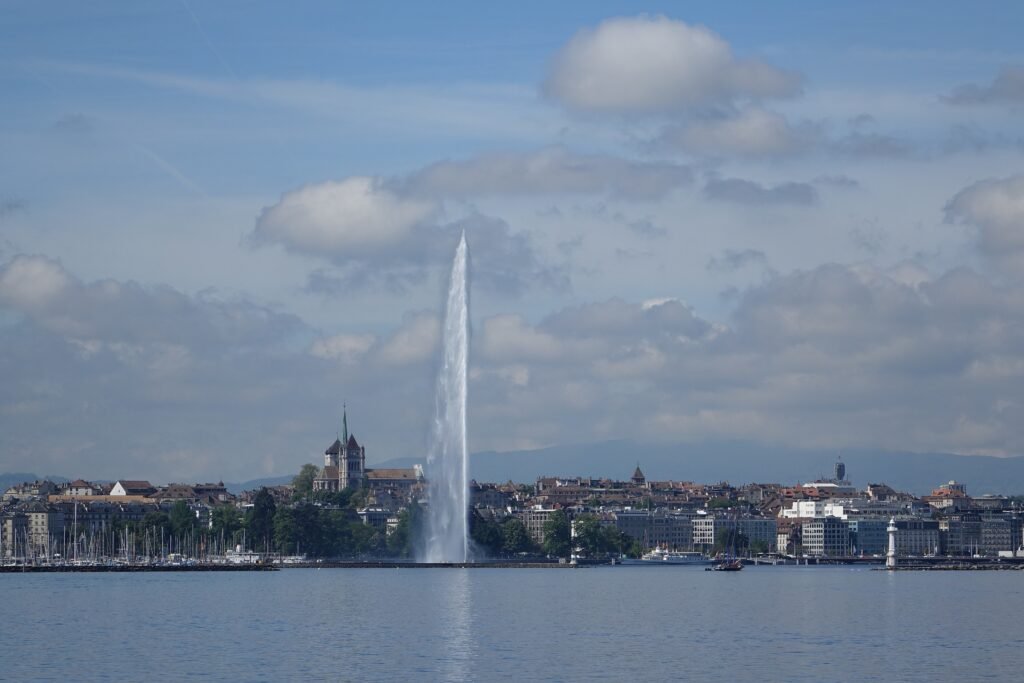 Geneva Jet d’Eau rising from Lake Geneva with St. Pierre Cathedral behind the waterfront