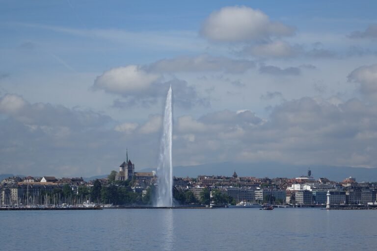 Geneva Jet d’Eau rising from Lake Geneva with St. Pierre Cathedral behind the waterfront