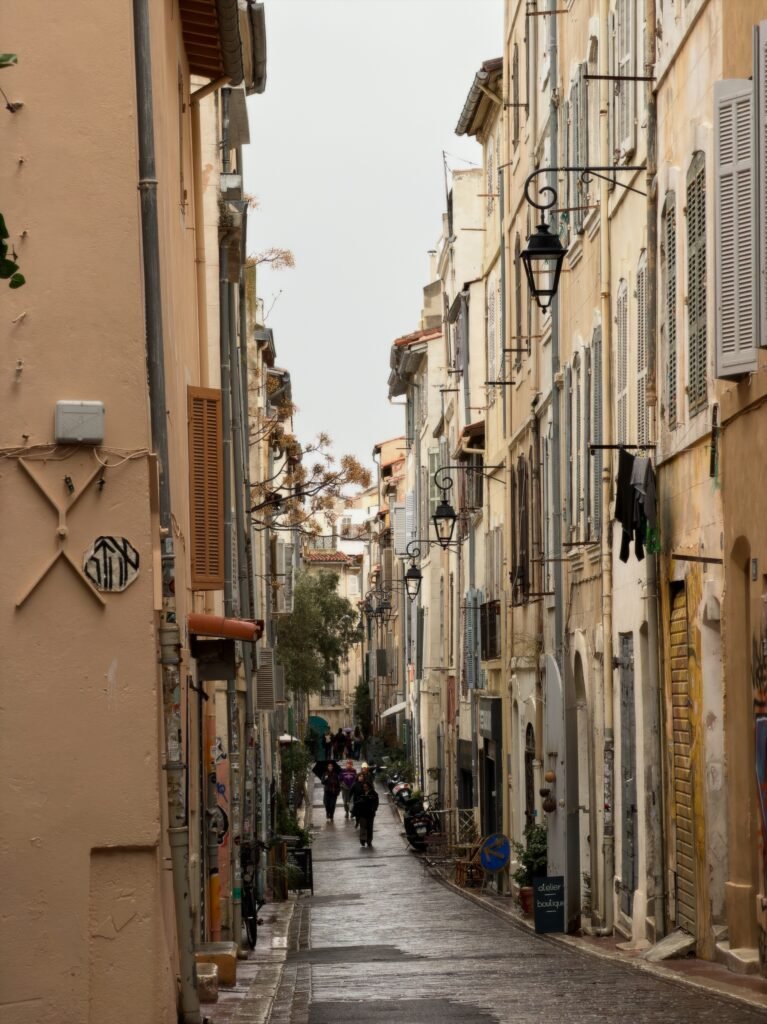 Narrow pedestrian street between colorful buildings in Le Panier, Marseille