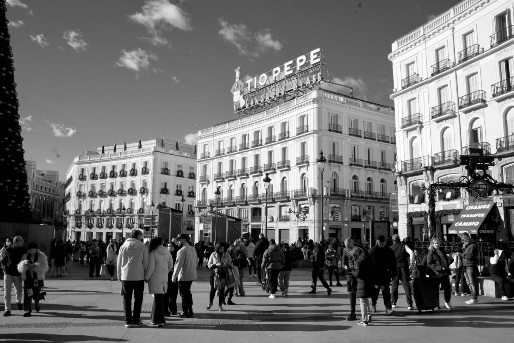 Pedestrians crossing the open space of Puerta del Sol in Madrid