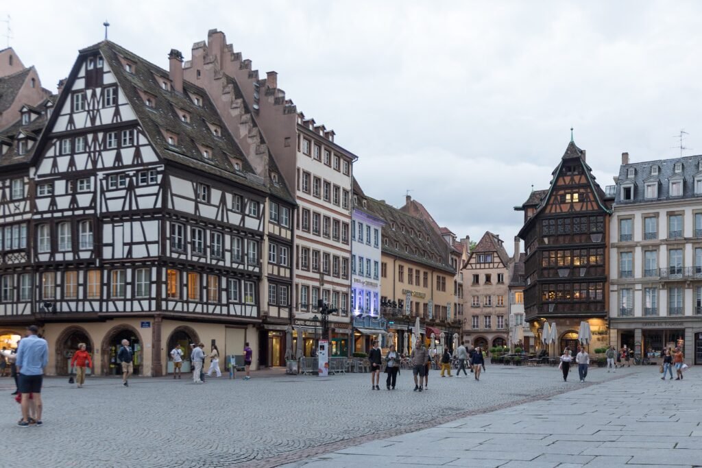 Pedestrians crossing Place de la Cathédrale among historic buildings in Strasbourg