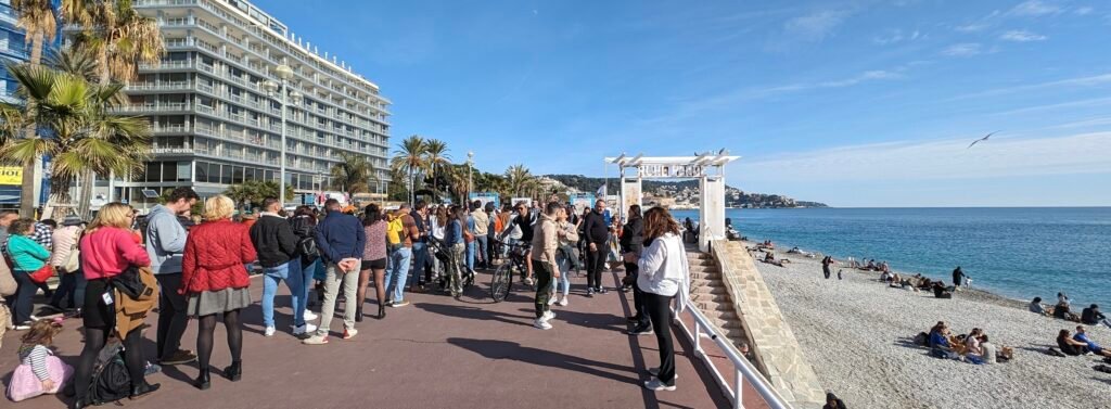 People walking along the Promenade des Anglais beside the Mediterranean in Nice