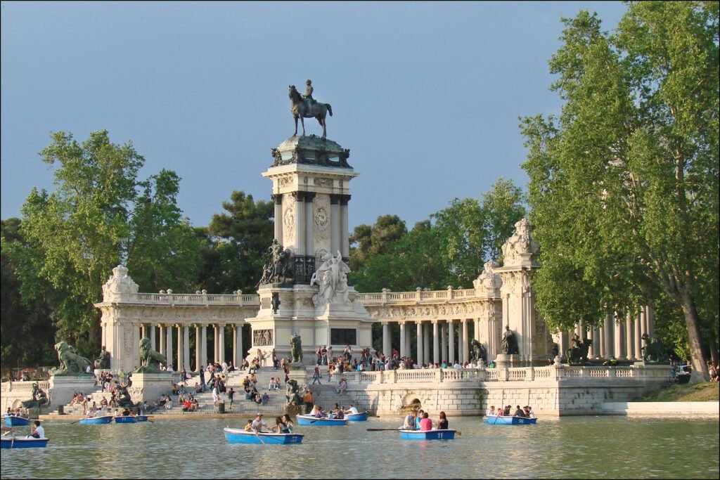 Retiro Park lake with boats and the monument to Alfonso XII in Madrid