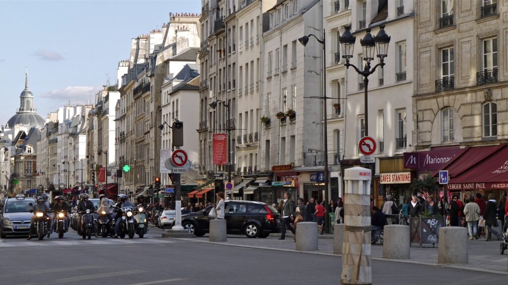 Pedestrians, cafés and traffic along Rue Saint-Antoine in the Marais district of Paris