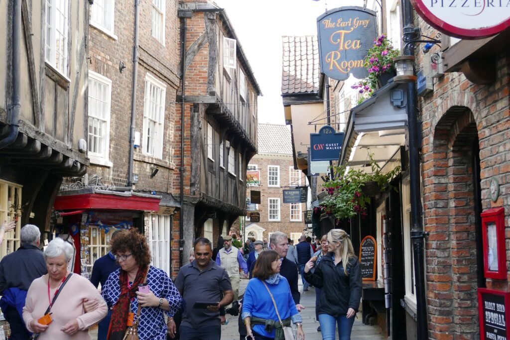 Pedestrians walking through the narrow timber-framed Shambles in York