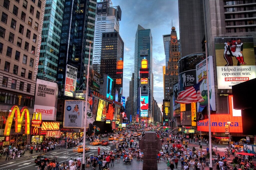 Times Square in Midtown Manhattan with wide sidewalks, pedestrians and illuminated billboards