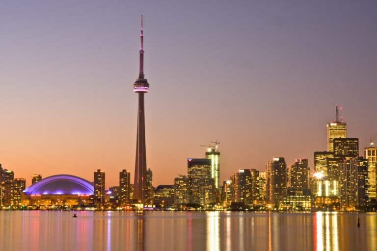 Toronto skyline and CN Tower across the harbour at dusk