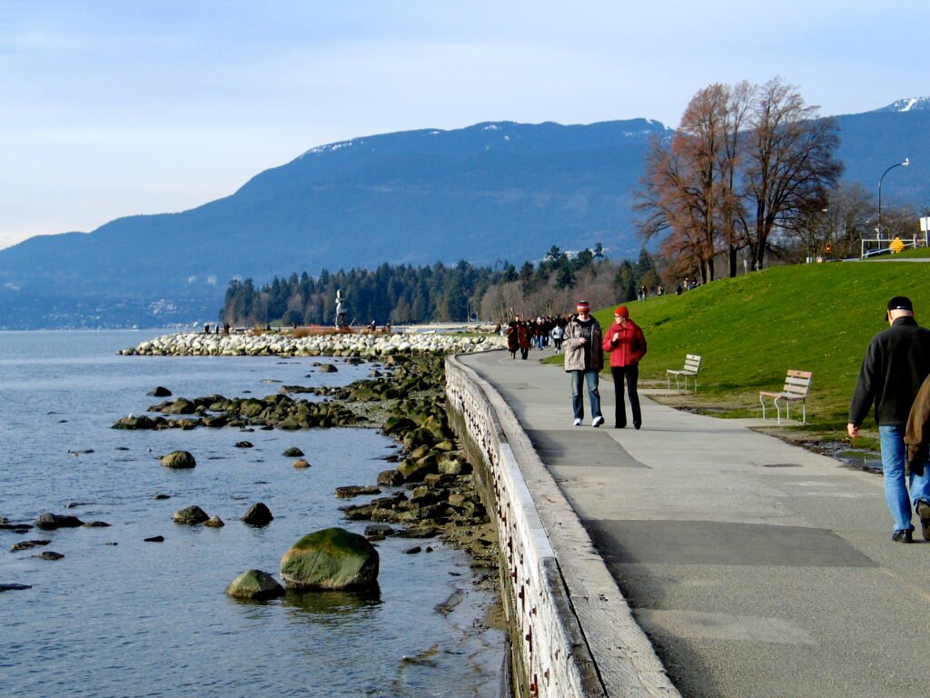 People walking along Vancouver’s seawall beside English Bay and Stanley Park