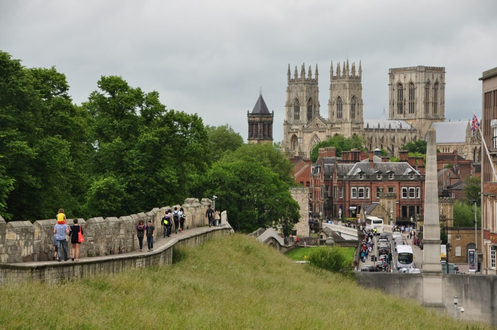 Visitors walking York City Walls with York Minster rising behind the historic centre