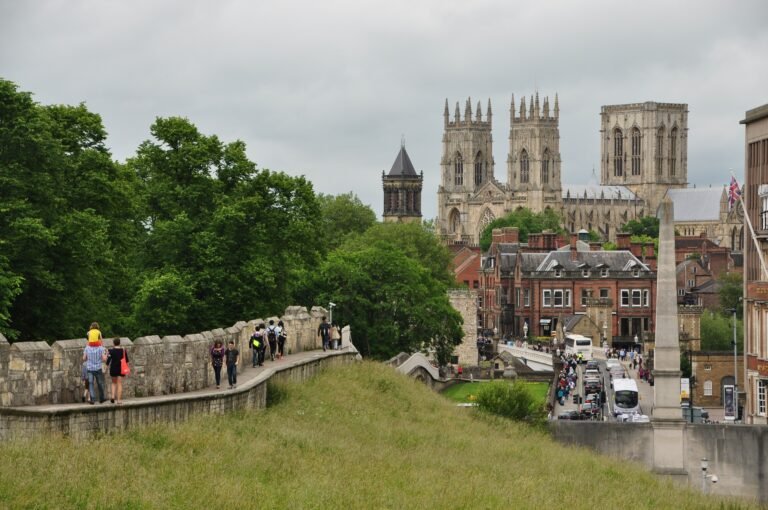 Visitors walking York City Walls with York Minster rising behind the historic centre