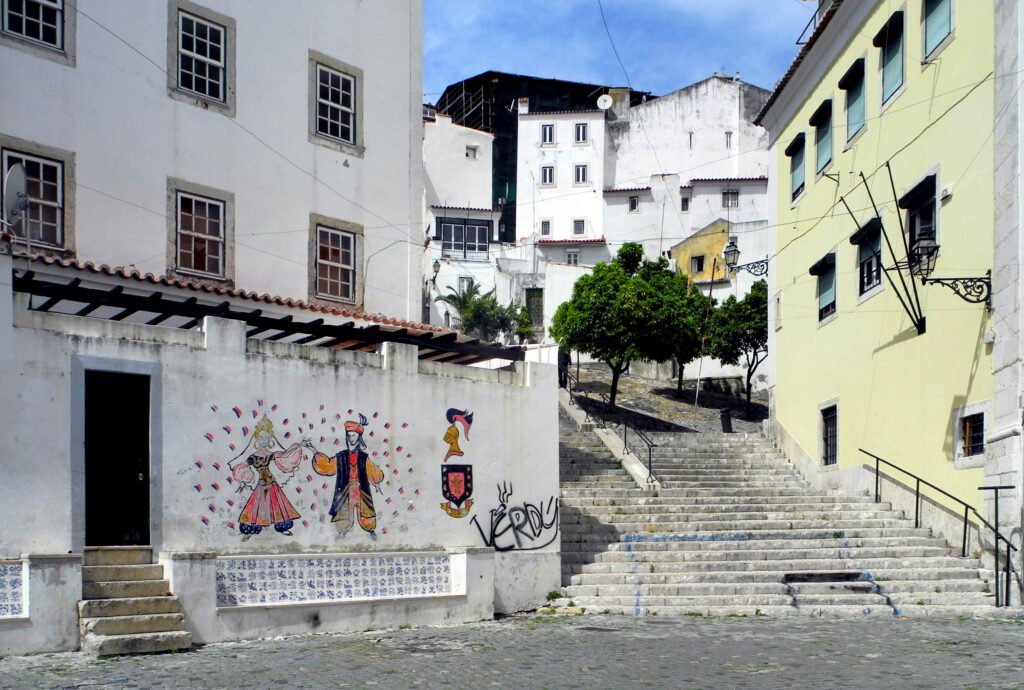 Broad stone stairway climbing between buildings in Lisbon's Alfama district