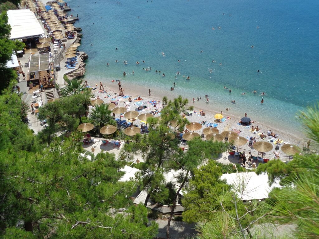 Arvanitia Beach beneath green and rocky slopes in Nafplio