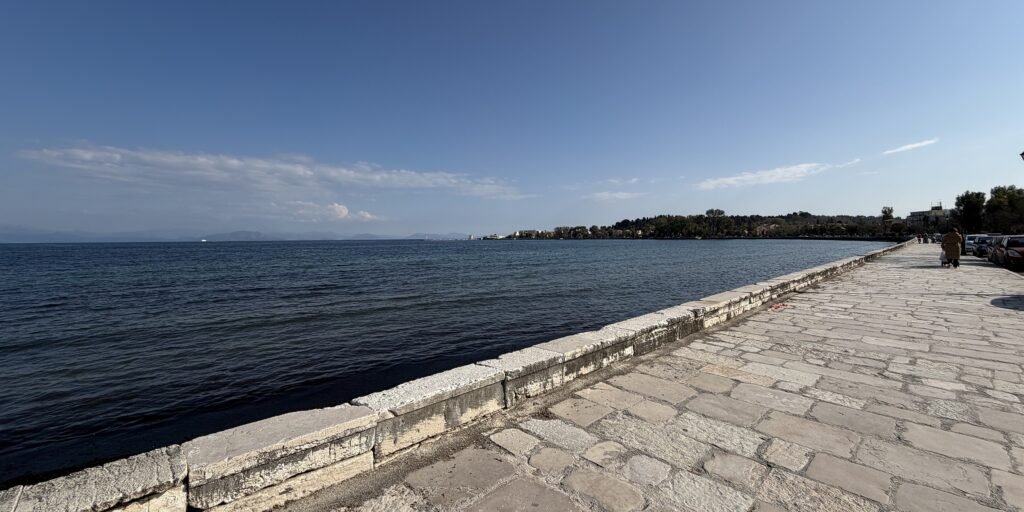Stone waterfront promenade beside Garitsa Bay in Corfu Town