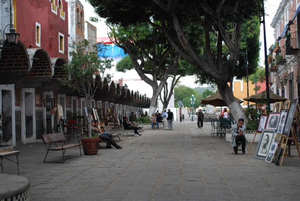 Pedestrian walkway with trees and outdoor artwork in Barrio del Artista, Puebla