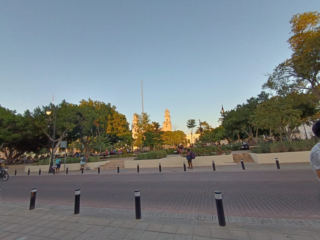 Plaza Grande in Mérida with trees, pedestrian space and cathedral towers beyond