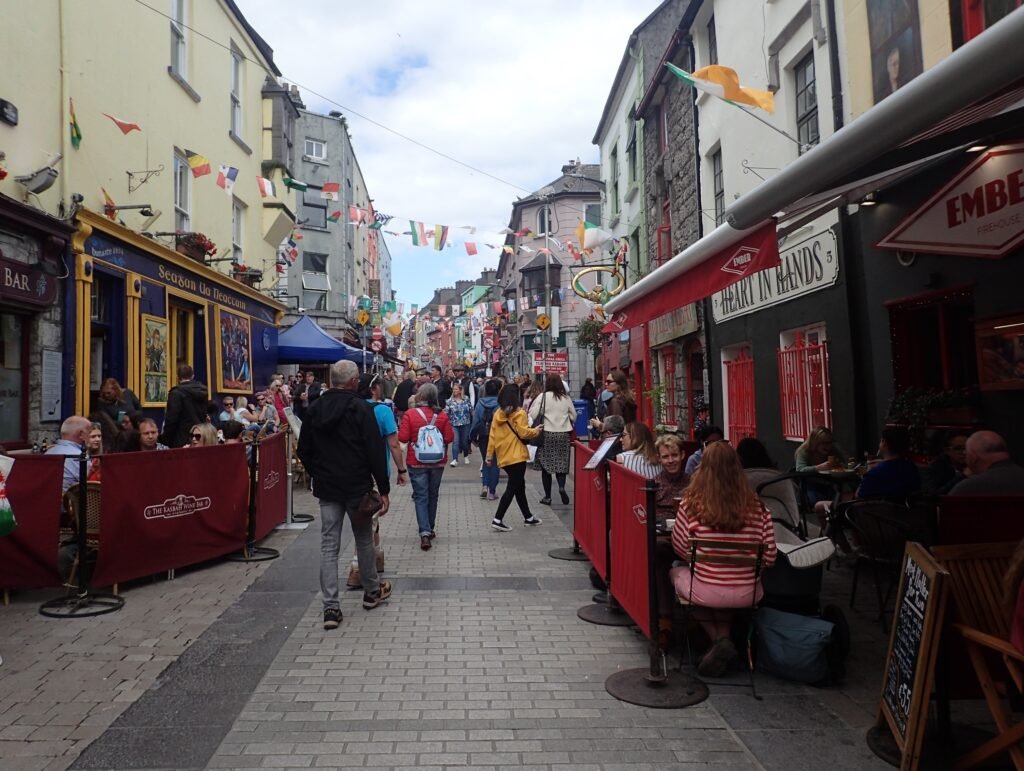 Pedestrians walking along busy Quay Street in Galway