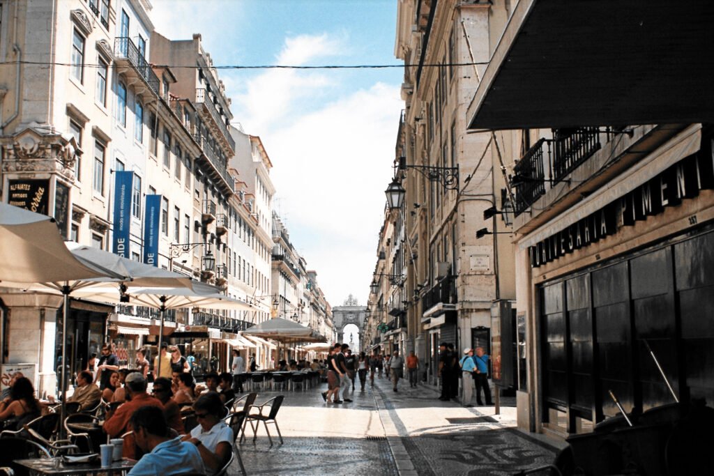 Pedestrians and café seating on Rua Augusta in Lisbon’s Baixa district