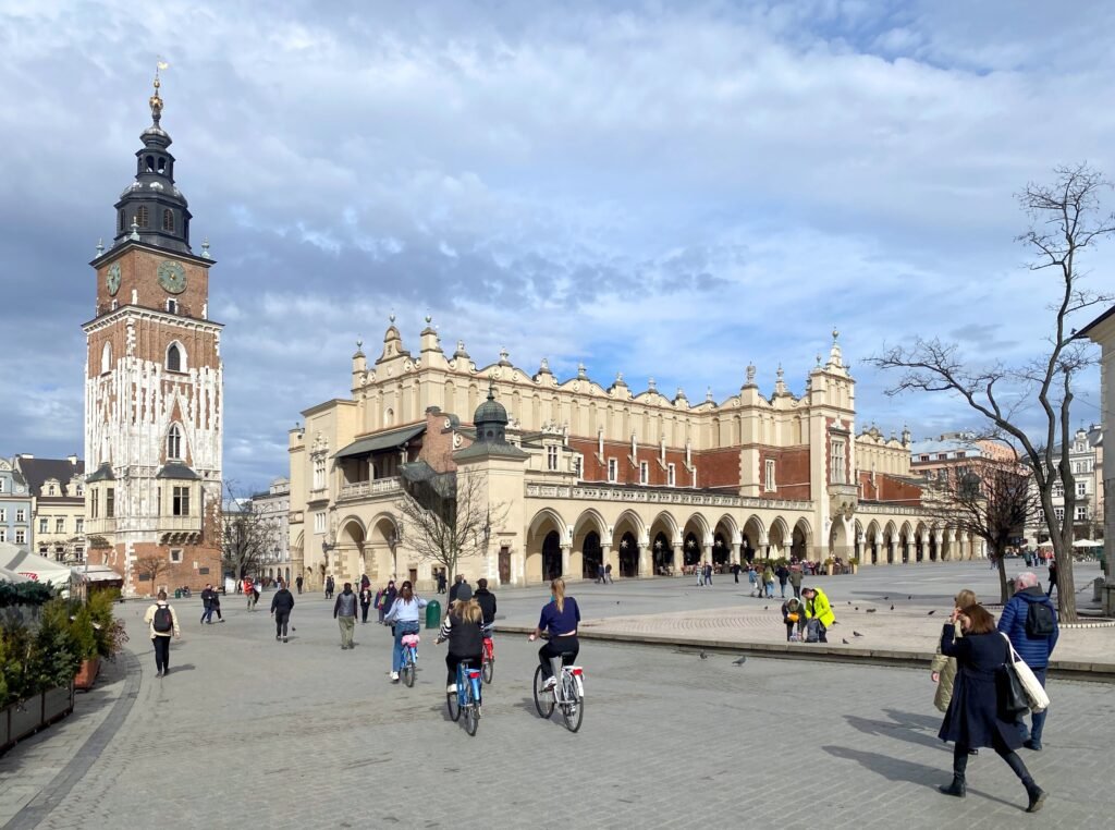 Pedestrians crossing Rynek Główny beside the Cloth Hall in Kraków