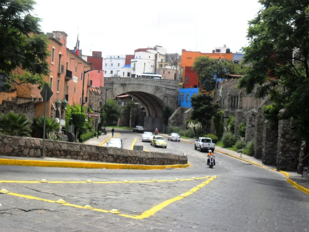Steep narrow paved street climbing between colorful buildings in Guanajuato