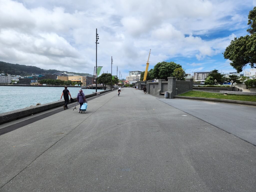 Pedestrians walking along the broad Wellington Waterfront promenade